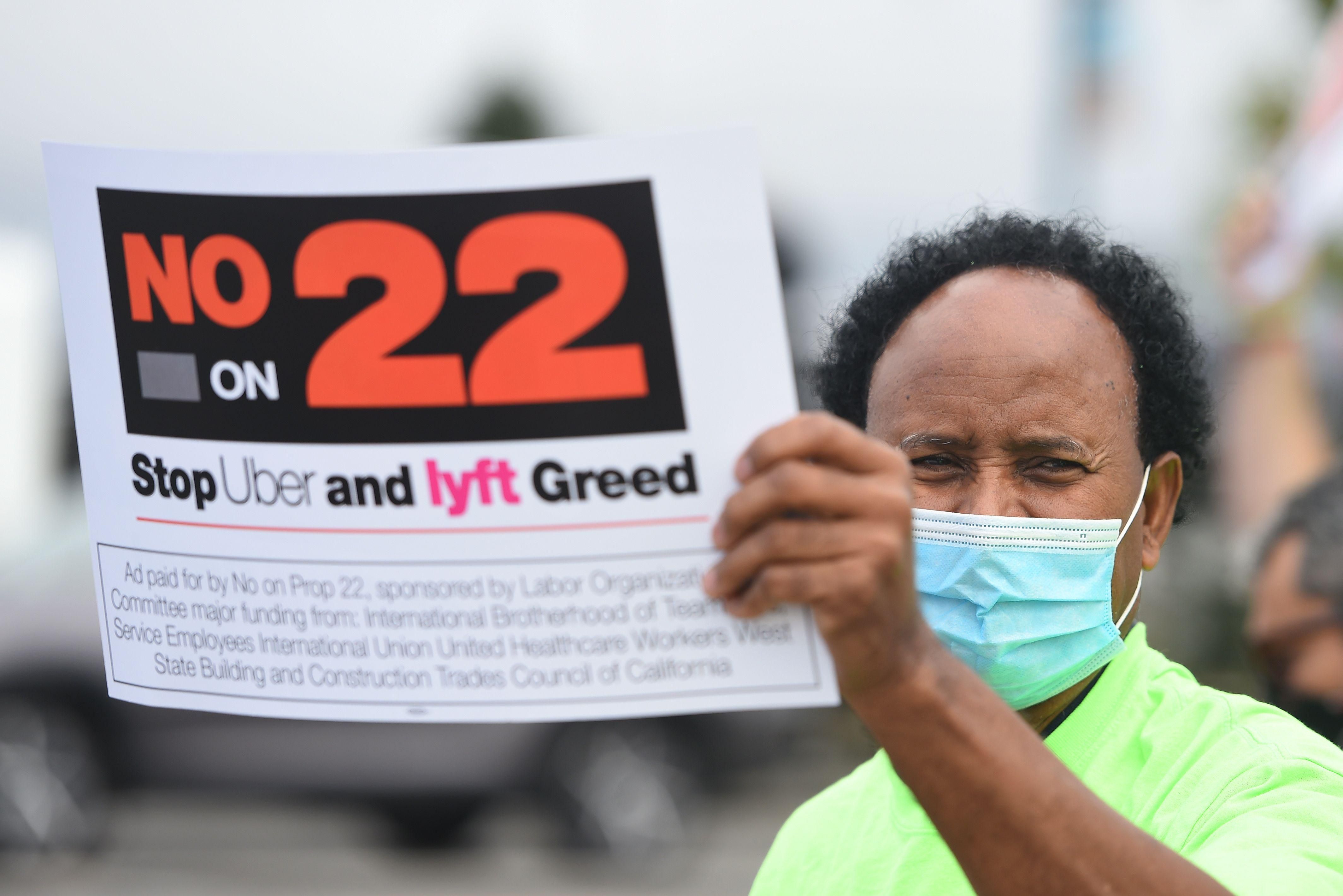A rideshare driver holds up a sign supporting a 'No' vote on Prop 22 in Oakland, California on October 9, 2020. (Photo: Josh Edelson/AFP via Getty Images)
