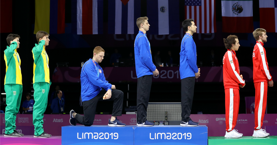 Gold medalist Race Imboden of United States takes a knee during the National Anthem Ceremony in the podium of Fencing Men's Foil Team Gold Medal Match Match on Day 14 of Lima 2019 Pan American Games at Fencing Pavilion of Lima Convention Center on August 09, 2019 in Lima, Peru. (Photo: Leonardo Fernandez/Getty Images)