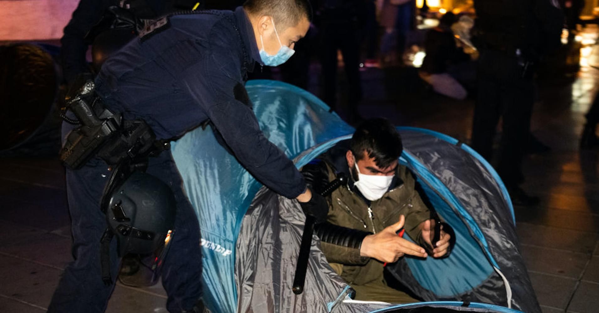 A French police officer evicts a migrant from a tent in Place de la République in Paris on November 23, 2020. (Photo: Jerome Gilles/NurPhoto via Getty Images)