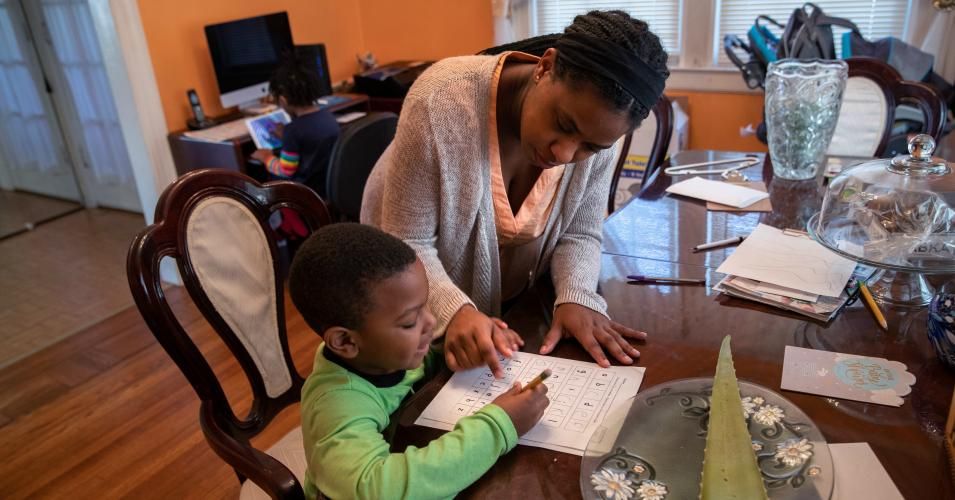 Geri Andre-Major helps her son Max, 5, with his school work on March 26, 2020 in Mount Vernon, New York. Andre-Major said she was furloughed as a pre-school teacher at Chelsea Piers Connecticut on March 13. 