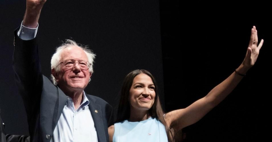 Sen. Bernie Sanders (I-Vt.) and Rep. Alexandria Ocasio-Cortez (D-N.Y.), wave to the crowd at the end of a campaign rally in Wichita, Kansas on July 20, 2018. 