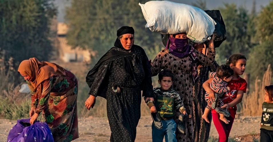 Syrian Arab and Kurdish civilians flee amid Turkish bombardment on Syria's northeastern town of Ras al-Ain in the Hasakeh province along the Turkish border on October 9, 2019.
