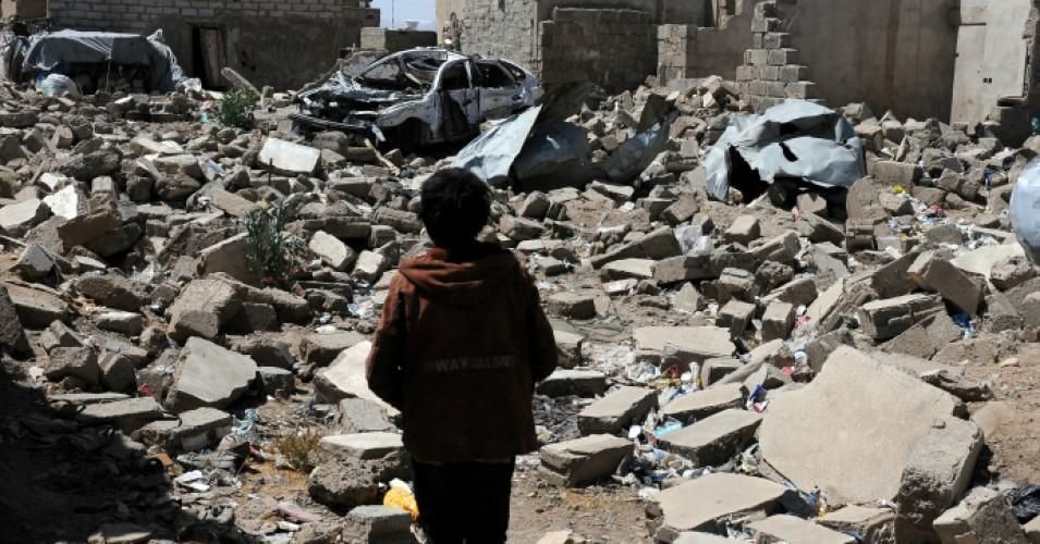 A boy stands on rubble 
