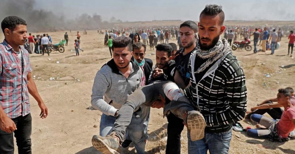Palestinians carry a demonstrator injured during clashes with Israeli forces near the border between the Gaza strip and Israel.