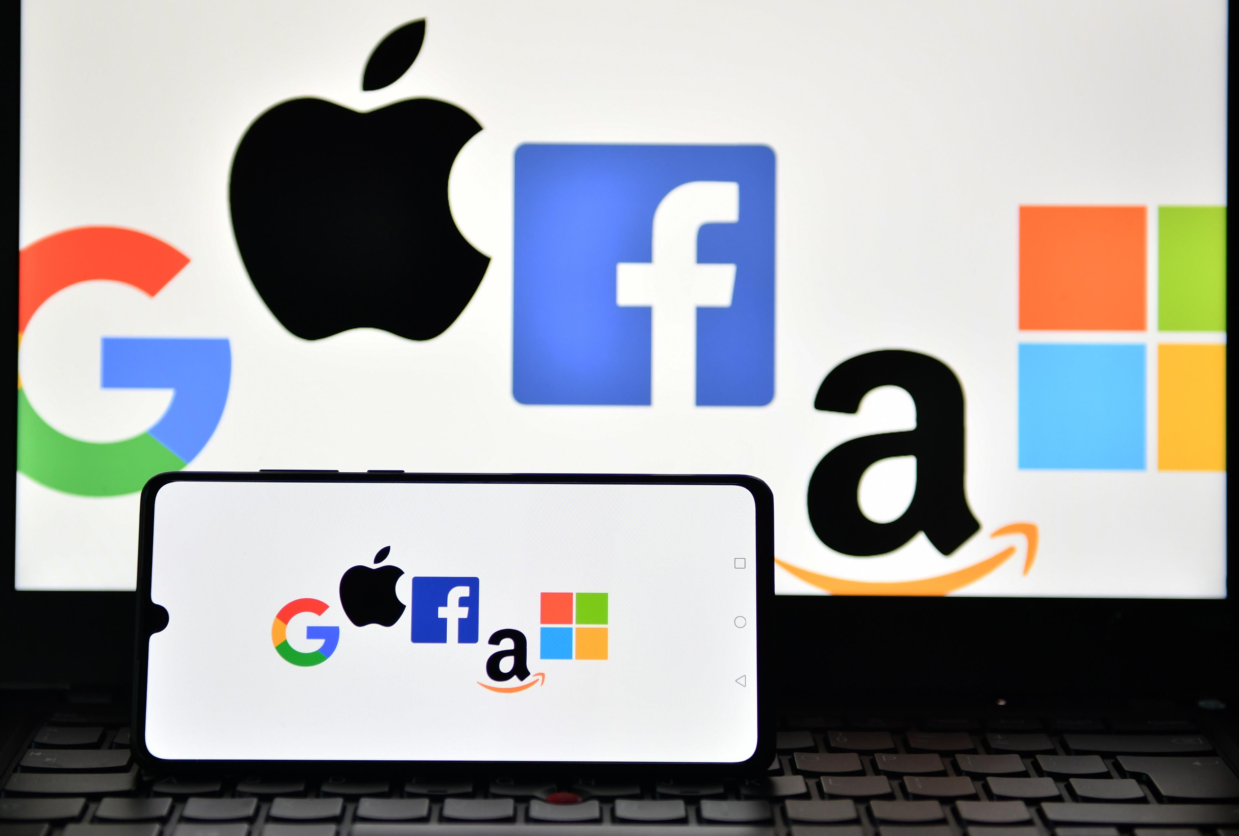 An illustration picture taken in London on December 18, 2020 shows the logos of Google, Apple, Facebook, Amazon, and Microsoft displayed on a mobile phone and a laptop screen. (Photo: Justin Tallis/AFP via Getty Images)