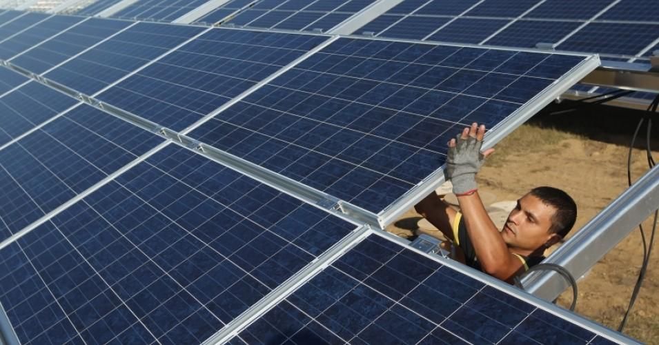 A worker installs solar panels at the Solarpark Eggersdorf solar park on September 4, 2012 near Muencheberg, Germany. 