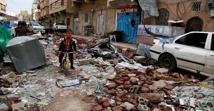A Yemeni boy rides a bike on rubble of houses destroyed in a recent airstrike carried out by warplanes of the Saudi-led coalition, on May 23, 2019 in Sana'a, Yemen.