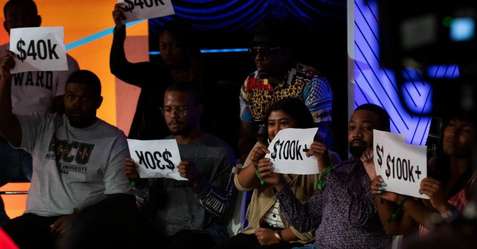Audience members hold signs during the BET special "Young, Gifted, and Broke: Our Student Loan Crisis" on September 10, 2019 at Howard Theater in Washington, D.C.