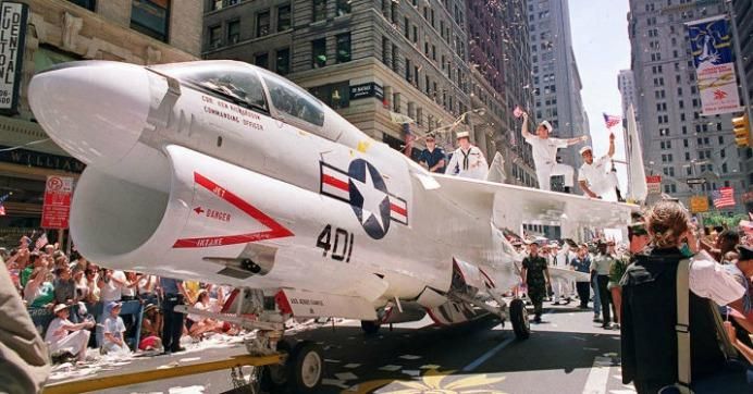 A Navy A-7 Corsair jet is pulled down Broadway as sailors rejoice on its wings during the Operation Welcome Home ticker-tape parade in New York City on June 10, 1991