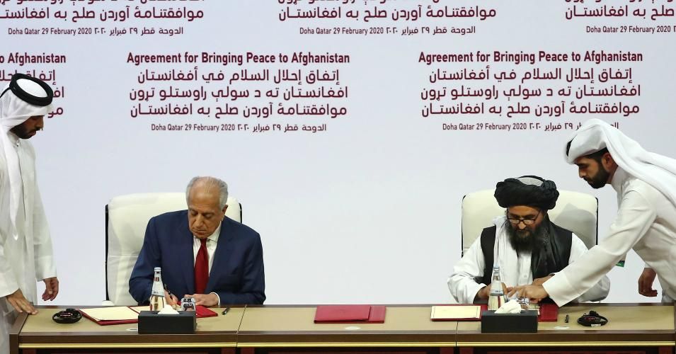 US Special Representative for Afghanistan Reconciliation Zalmay Khalilzad and Taliban co-founder Mullah Abdul Ghani Baradar sign a peace agreement during a ceremony in the Qatari capital Doha on February 29, 2020. - The United States signed a landmark deal with the Taliban, laying out a timetable for a full troop withdrawal from Afghanistan within 14 months as it seeks an exit from its longest-ever war. Pompeo called on the Taliban to honour its commitments to sever ties with jihadist groups as Washington s