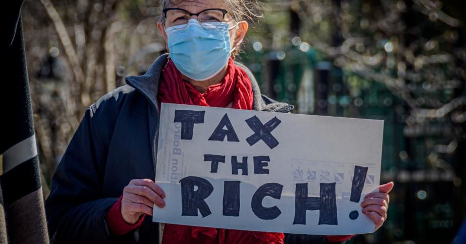 A person holds a sign urging lawmakers to "Tax the Rich" at a protest in New York City on March 29, 2021. (Photo: Erik McGregor/LightRocket via Getty Images)