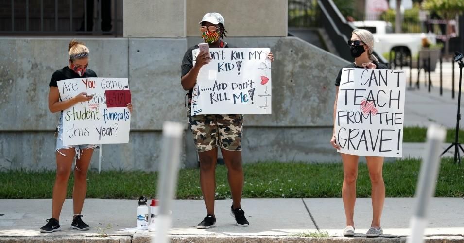 School counselor Chloe Gerbec and teachers Malikah Armbrister and Brittany Myers stand in protest in front of the Hillsborough County Schools District Office on July 16, 2020 in Tampa, Florida. Teachers and administrators from Hillsborough County Schools rallied against the reopening of schools due to health and safety concerns amid the Covid-19 pandemic.