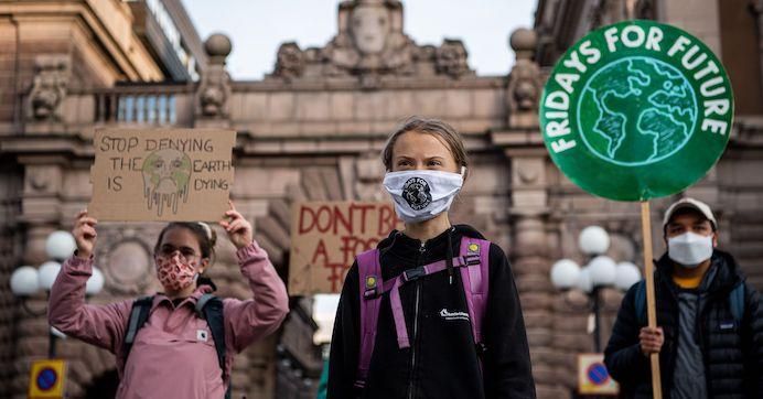 Swedish climate activist Greta Thunberg (C) takes part in a Fridays For Future protest in front of the Swedish Parliament (Riksdagen) in Stockholm on September 25, 2020.