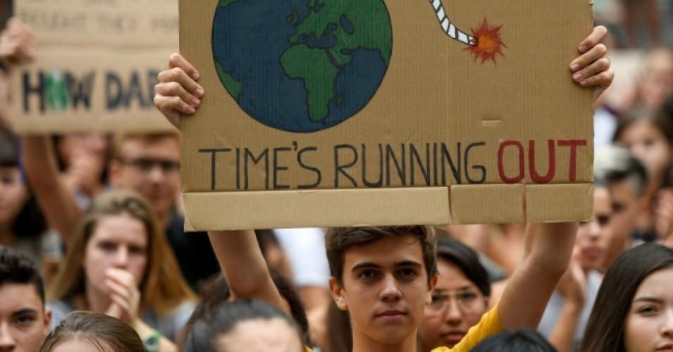 A demonstrator holds a placard reading "time is running out" during a global youth climate action strike in Barcelona, on September 27, 2019 at the end of a global climate change week. 