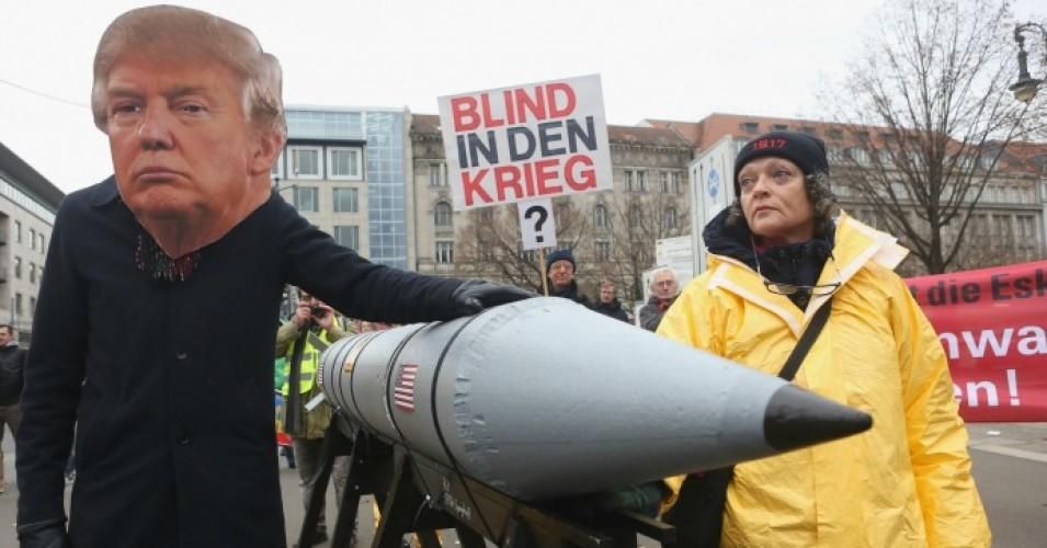An activist with a mask of U.S. President Donald Trump marches with a model of a nuclear rocket during a demonstration against nuclear weapons on November 18, 2017 in Berlin. 
