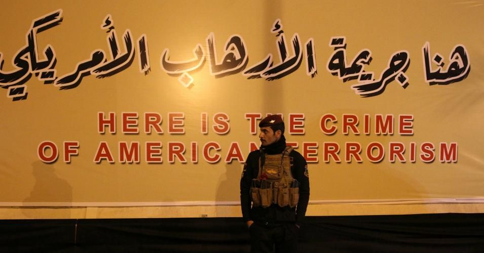 An Iraqi fighter of the Hashed al-Shaabi stands in front of a banner at the site of the January 3, 2020 US drone strike on Qasem Solemani at Baghdad Airport, in Baghdad, Iraq on January 2, 2021. On January 3, Iraq marked the first anniversary of the killing of Iranian Gen. Qassim Soleimani and others in a drone strike at Baghdad International Airport that was authorized by U.S. President Trump. (Photo: Ahmad Al-Rubaye/AFP via Getty Images)