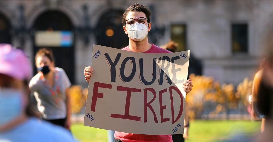 A man holds a sign reading "You're Fired" during a worker's rally in Copley Square in Boston just after Joe Biden was declared the president-elect in Boston on November 7, 2020.
