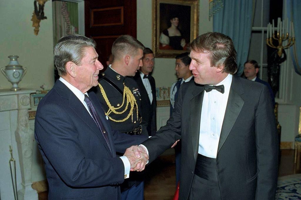 Future President Donald Trump is greeted by his ideological precursor President Ronald Reagan at a 1987 White House reception. 