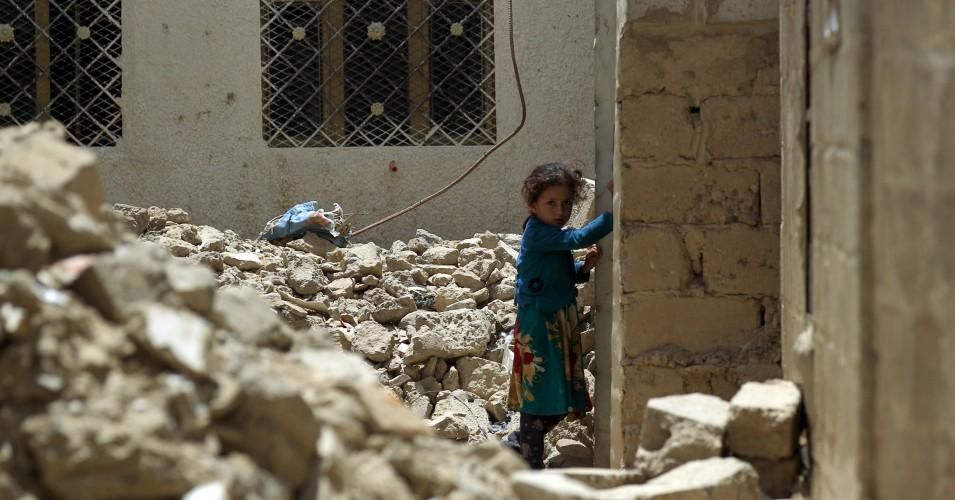 A young girl stands amidst the ruins of a building destroyed during past Saudi-led coalition air strikes, in the province of Amran, some 50 kilometres (30 miles) north of the Yemeni capital Sanaa, on July 6, 2019.