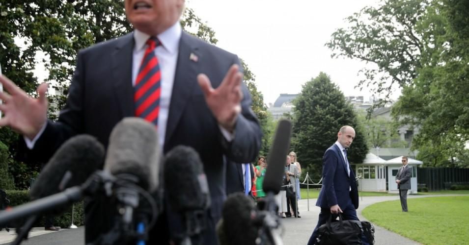 White House senior adviser Stephen Miller walks behind President Donald Trump as he talks to reporters before they depart the White House June 8, 2018 in Washington, D.C. 
