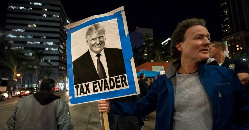 People take part in a protest against the Republican tax bill in Los Angeles, California on December 4, 2017.