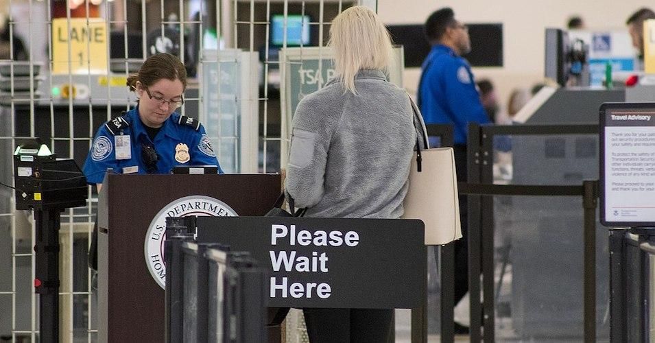 A Transportation Security Administration agent at a checkpoint verifying passenger identification in John Glenn Columbus International Airport. 