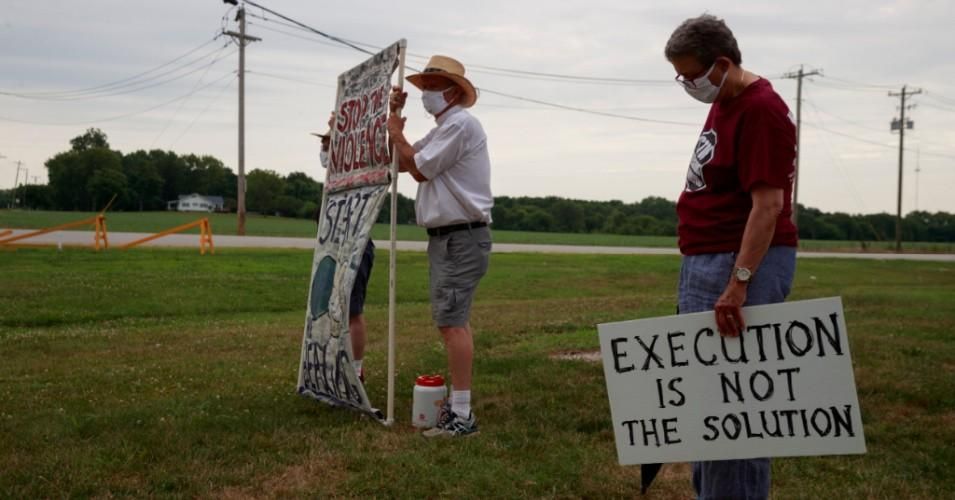 Glenda Breeden, Reverend Bill Breeden, and Karen Burkhart stand outside the Terre Haute Federal Correctional Complex to protest before death row inmate Wesley Ira Purkey was scheduled to be executed by lethal injection in July 2020.