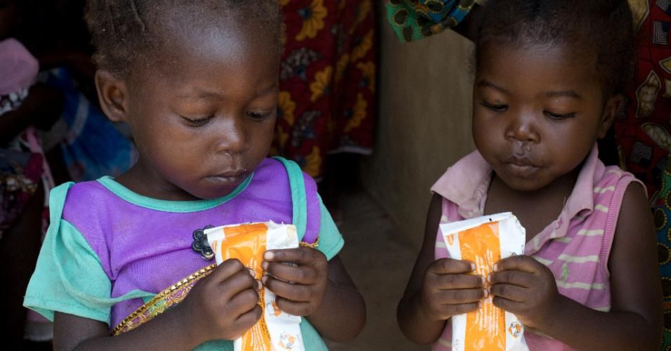 Two children eat a food supplement at a government clinic in the Democratic Republic of the Congo. (Photo: Prinsloo/UNICEF)