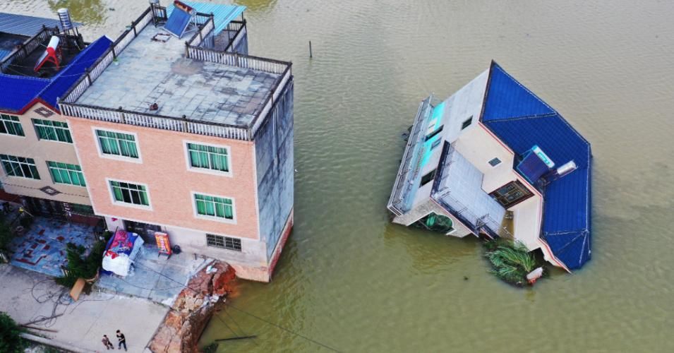 In the wake of continuous downpours in the Jiangxi Province of China, a flooded house crumbled into Pyong Lake on July 13, 2020. (Photo: Liu Zhankun/China News Service via Getty Images)