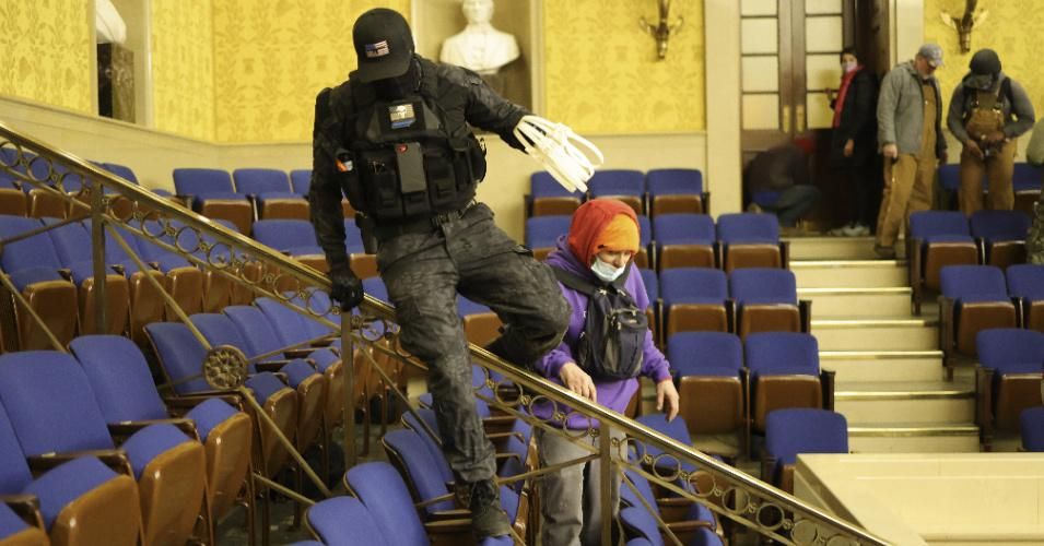 Carrying plastic restraints, a member of the pro-Trump insurrectionist mob is seen inside the Senate Chamber on January 06, 2021 in Washington, DC. (Photo: Win McNamee/Getty Images)