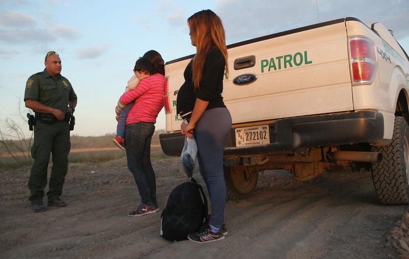 Refugees from El Salvador turn themselves in to a U.S. border agent near Rio Grande, Texas.