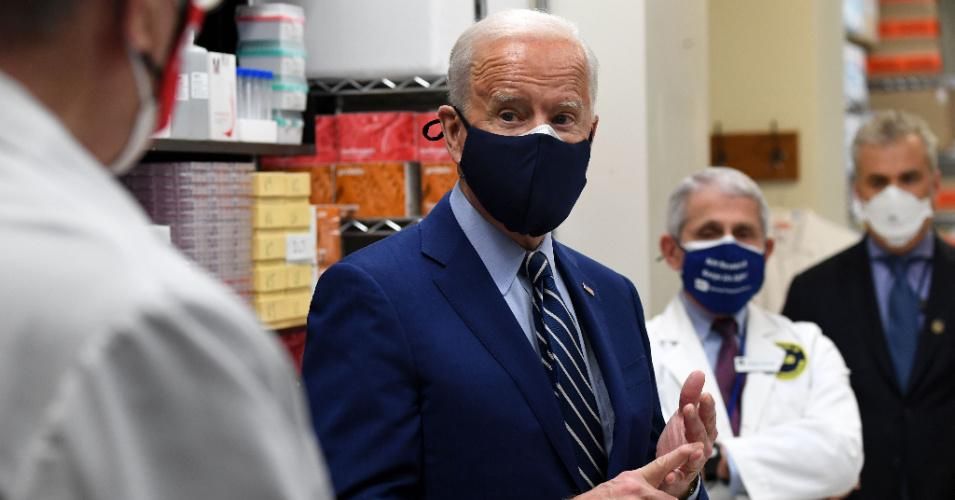 President Joe Biden speaks to Dr. Barney Graham (L), flanked by White House Chief Medical Adviser on Covid-19 Dr. Anthony Fauci (2nd R), as he tours the Viral Pathogenesis Laboratory at the National Institutes of Health in Bethesda, Maryland on February 11, 2021.