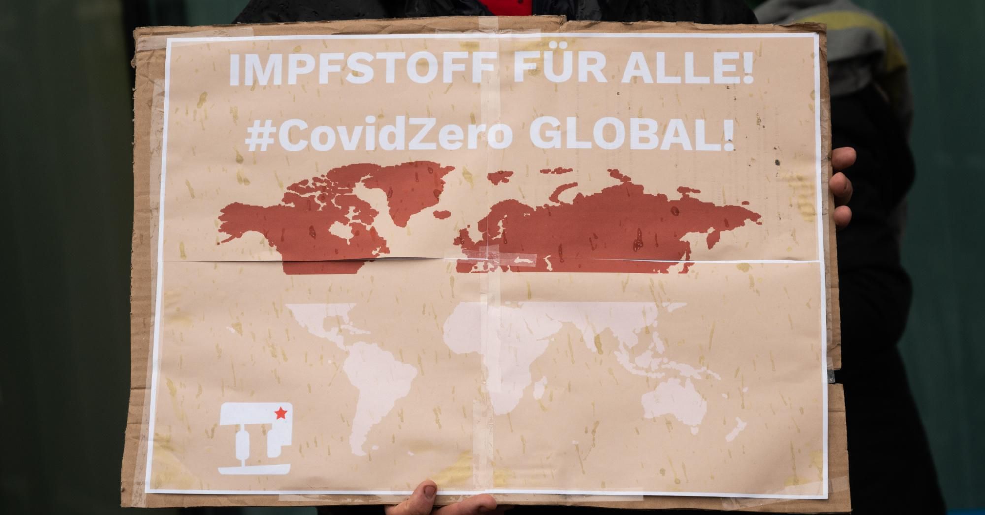 A demonstrator carries a banner that reads "Vaccine For All! #CovidZero Global!" during a protest in front of Pfizer headquarters in Berlin, Germany on January 23, 2021.