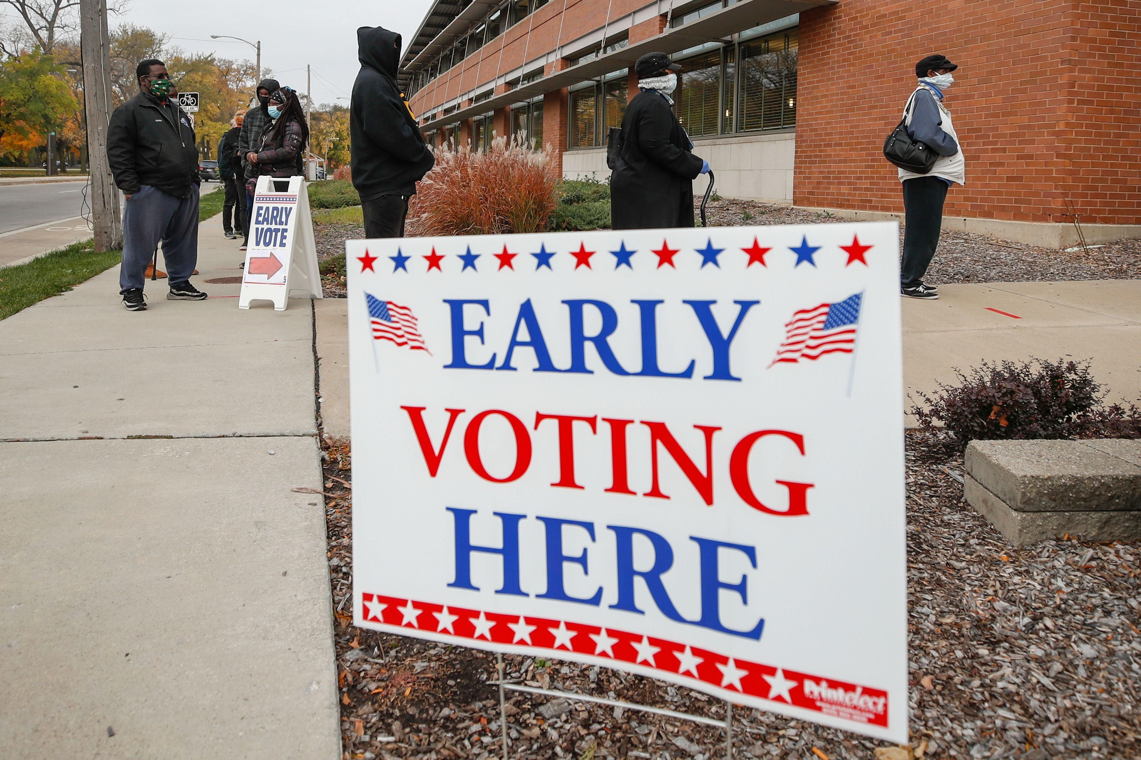 People wait in line outside the Washington Park Library to cast their ballots on the first day of in-person early voting in Milwaukee, Wisconsin on October 20, 2020. (Photo: Kamil Krzaczynski/AFP via Getty Images)