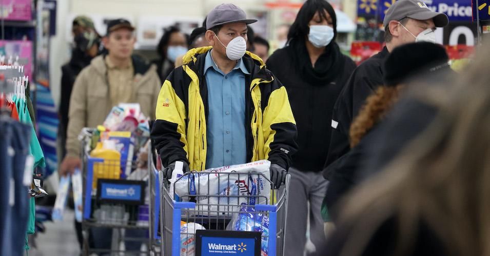 People wearing masks and gloves wait to checkout at Walmart on April 03, 2020 in Uniondale, New York. 