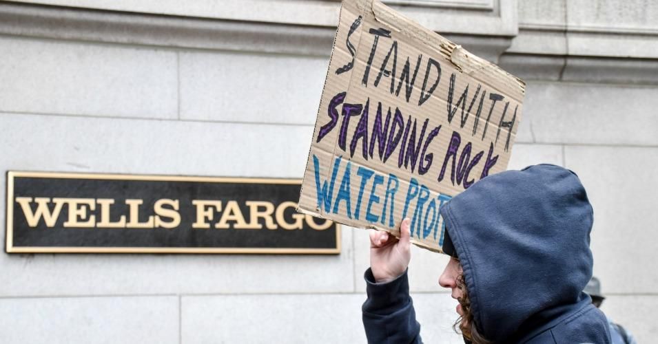 A protest calls for divestment from Wells Fargo for funding the Dakota Access Pipeline.