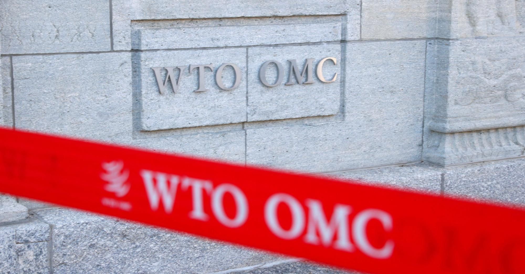 A picture taken on April 1, 2021 shows a sign on the facade at the headquarters of the World Trade Organisation (WTO) in Geneva.