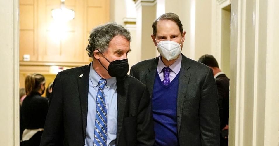 Democratic Sens. Sherrod Brown (Ohio) and Ron Wyden (Ore.) walk during a break in the impeachment trial of former President Donald Trump at the U.S. Capitol on February 10, 2021 in Washington, D.C. 
