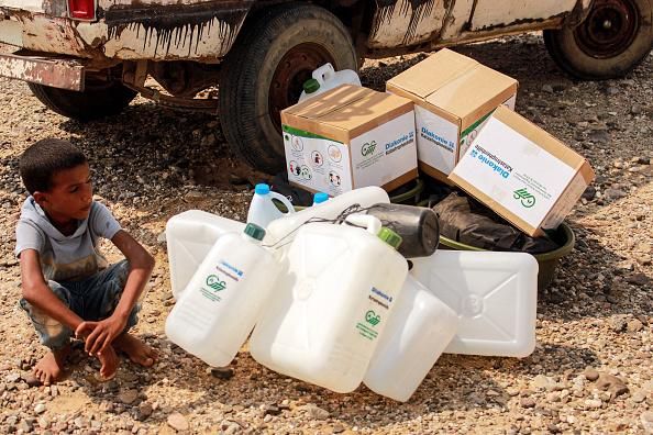 A child waits next to jerry cans and aid packages as Yemenis displaced by conflict receive humanitarian aid provided by the Abs Development Organisation in the northern province of Hajjah on September 17, 2020. (Photo: Essa Ahmed/AFP) 