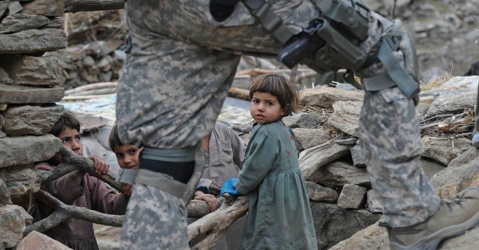 Afghan children look on as a US soldier from the Provincial Reconstruction team (PRT) Steel Warriors patrols in the mountains of Nuristan Province on December 19, 2009. (Photo: Tauseef Mustafa/AFP/Getty Images)