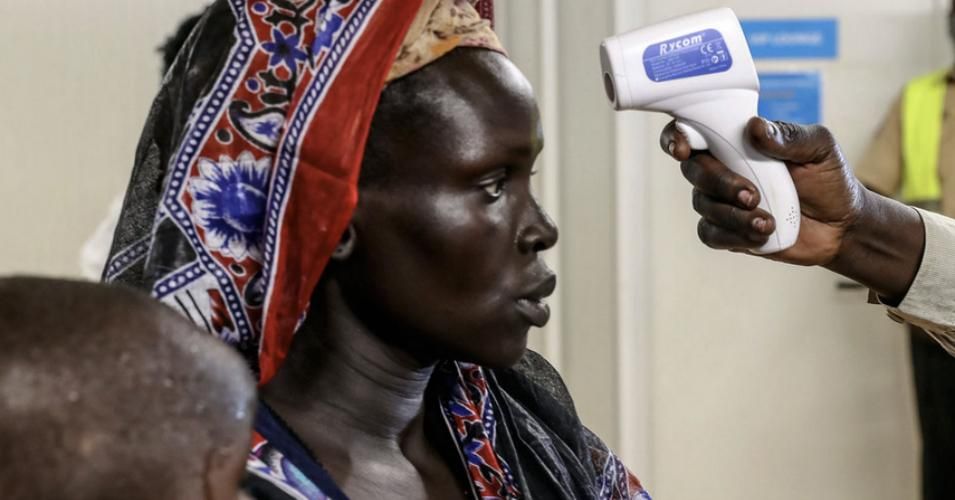 An internally displaced woman voluntarily returning to her home in Bentiu, South Sudan, is being checked for fever. (Photo: United Nations/Isaac Billy)