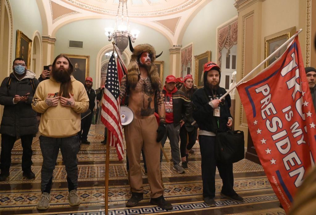 Supporters of US President Donald Trump, including member of the QAnon conspiracy group Jake Angeli, aka Yellowstone Wolf (C), enter the US Capitol on January 6, 2021, in Washington, DC. - Demonstrators breeched security and entered the Capitol as Congress debated the a 2020 presidential election Electoral Vote Certification. (Photo by SAUL LOEB/AFP via Getty Images)