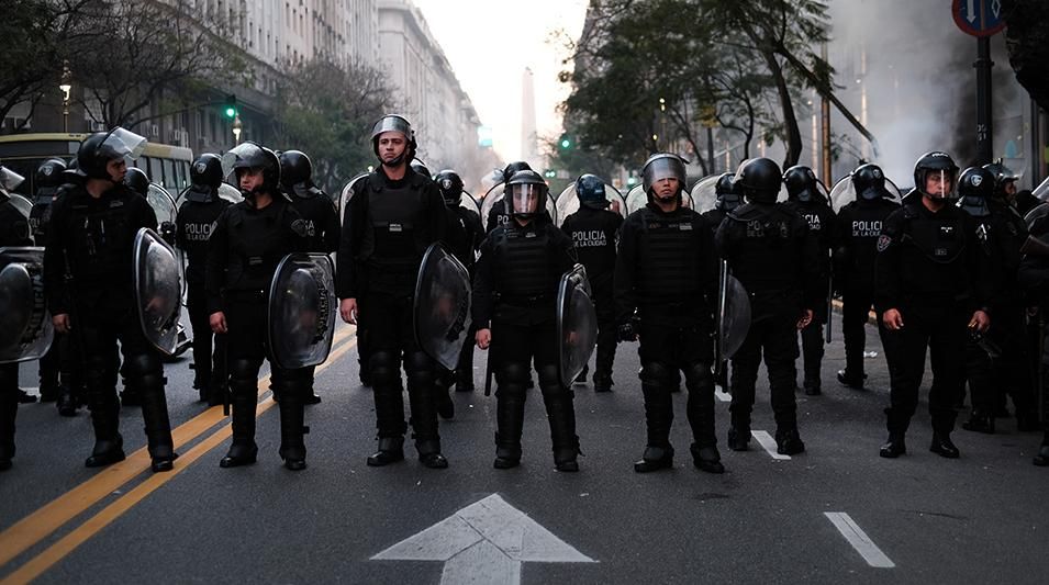 Riot police stand guard as dozens of people gather during a rally to show solidarity with protesters in Chile at the Chilean Consulate General on October 21, 2019 in Buenos Aires, Argentina.