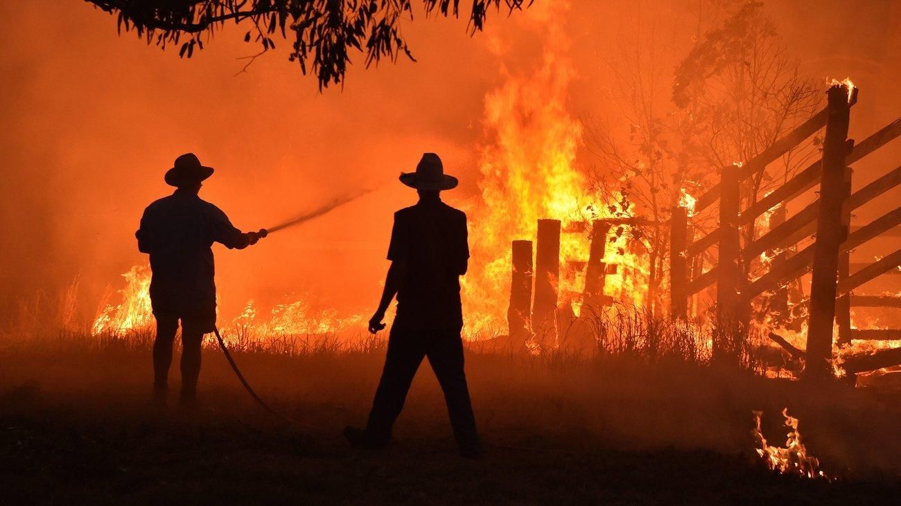 Residents defend a property from a bushfirein Taree, north of Sydney.(Photo: Peter Parks/AFP via Getty Images)