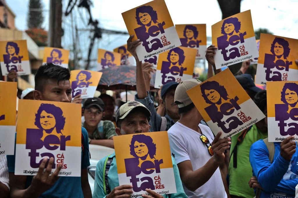 Members of the Council of Popular and Indigenous Organizations of Honduras (COPINH) hold posters with an image of slain indigenous leader and environmental activist Berta Caceres, as they demand a 526-year sentence for Roberto Castillo, executive president of Desarrollos Energeticos (DESA), as a preliminary hearing in the case against him resumes, in Tegucigalpa on October 10, 2019. (Photo by ORLANDO SIERRA/AFP via Getty Images)