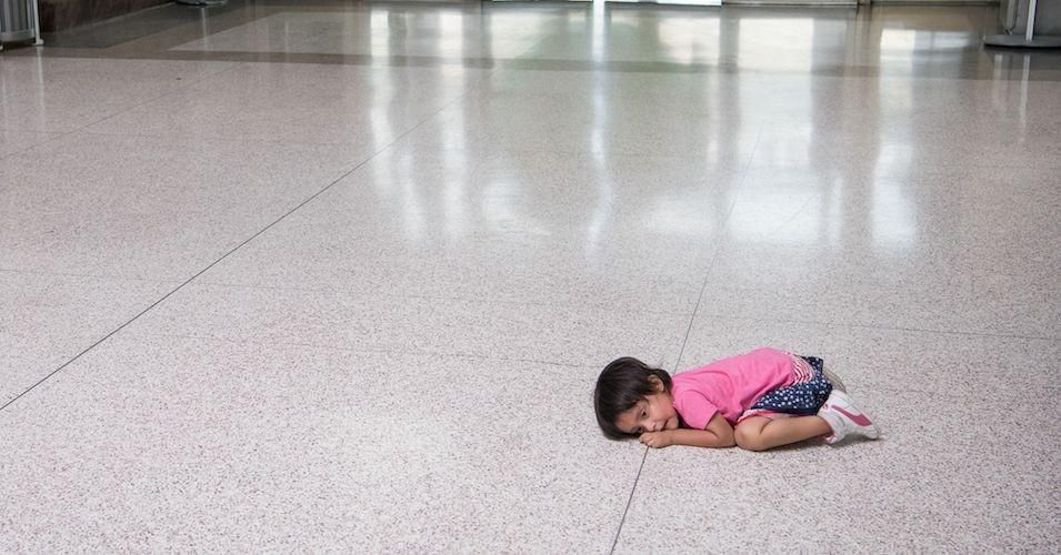 A young migrant girl sits on the floor as her father, recently released from federal detention with other Central American asylum seekers, gets a bus ticket at a bus depot on June 11, 2019, in McAllen, Texas. (Photo: Loren Elliott/AFP/Getty Images)