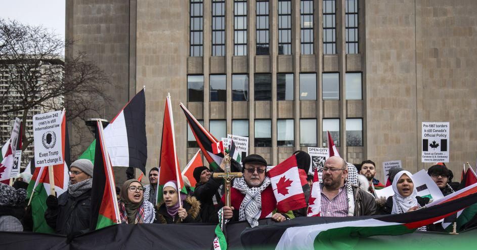 Protesters hold a giant Palestinian flag as they walk across University Avenue in front of the U.S. consulate, during a demonstration against the decision by U.S. President Donald Trump to recognize Jerusalem as Israel's capital on in Toronto, Canada, December 9, 2017. (Photo: Giordano Ciampini/Anadolu Agency/Getty Images)