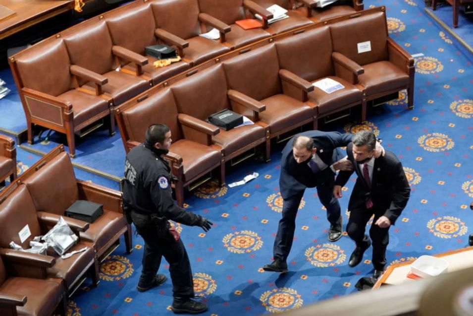 Members of congress run for cover as protesters try to enter the House Chamber during a joint session of Congress on January 06, 2021 in Washington, DC. Congress held a joint session today to ratify President-elect Joe Biden's 306-232 Electoral College win over President Donald Trump. A group of Republican senators said they would reject the Electoral College votes of several states unless Congress appointed a commission to audit the election results. (Photo by Drew Angerer/Getty Images)