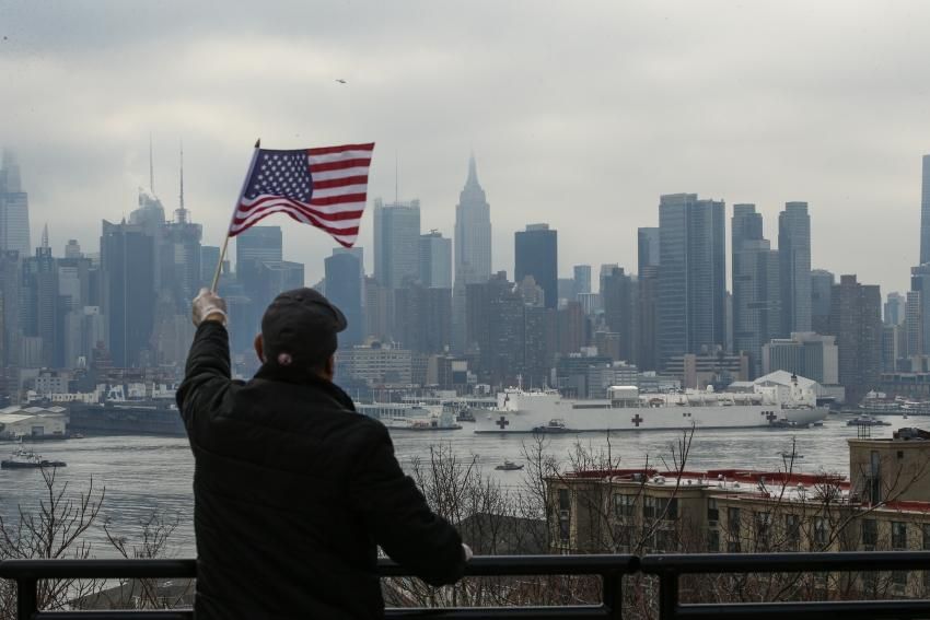 People watch the arrival of the USNS Comfort Ship on March 30, 2020 in New York as seen from Weehawken, New Jersey. The naval hospital has 1,000 beds and 12 operating rooms. The Comfort will not treat Covid-19 patients. (Photo by Kena Betancur/ VIEWpress via Getty Images) 