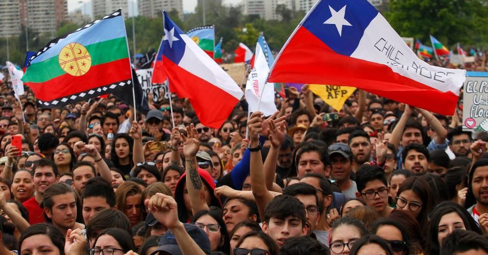 Demonstrators wave flags as they take part during the day of cultural activities 'El Derecho a Vivir en Paz' called by 'Movimiento Unidad Social' at Plaza O'Higgins on October 27, 2019 in Santiago, Chile. Unidad Social, an organization conformed by various social groups, has called society to be part of cultural activities in defence of human rights and against abuses, under the slogan #NoMasAbusos (No more abuses) people demand Sebastian Piñera's Government attention to issues such as health care, pension 